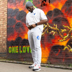 Person wearing a white outfit with colorful graffiti in the background